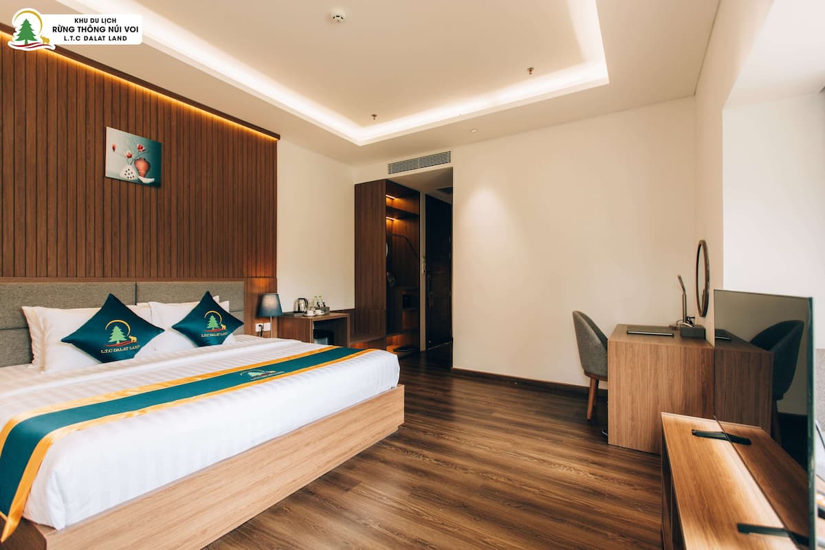 Ein Hotelzimmer mit Bett, Schreibtisch und Fernseher.