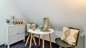 A small dining area with a white table, two chairs, a cabinet, and a potted plant. - Apartment 'Fewo-Keinath' with Wi-Fi (Winterlingen)