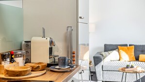 A modern kitchen with a coffee machine, wooden bowls, and a dining area with a sofa and a small table. - Apartment 'Fewo-Keinath' with Wi-Fi (Winterlingen)