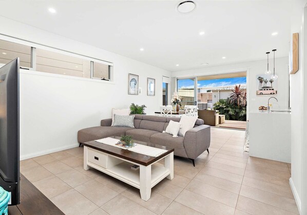 A modern living room with a sofa, coffee table, and TV.