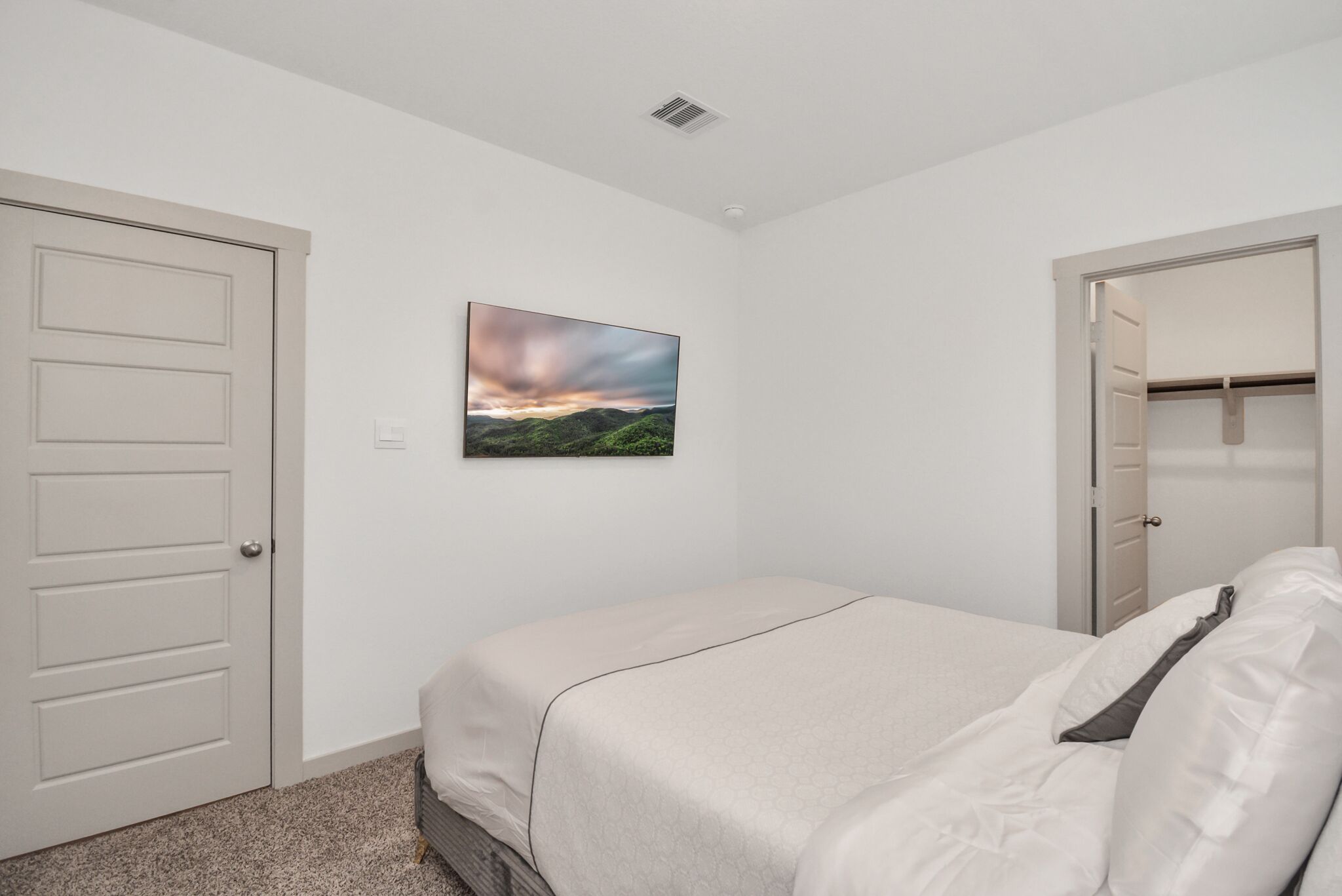 Ein Schlafzimmer mit Bett, Schrank und Tür.