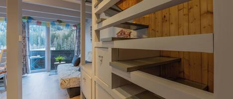 Un intérieur moderne avec un lit, des étagères intégrées et une vue sur un espace extérieur enneigé.
