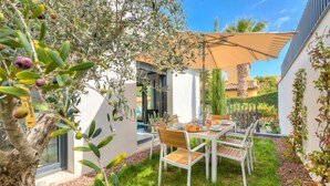 An outdoor patio with a table and chairs, surrounded by olive trees and a pergola. - Apt 2 bedroom - Terrace Near Saint-Tropez, St. Maxime, France (St. Maxime)