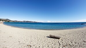 A beach with clear blue water, sandy shore, and a distant mountain range. - Apt 2 bedroom - Terrace Near Saint-Tropez, St. Maxime, France (St. Maxime)