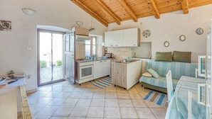 Une cuisine de taille réduite avec un plafond en bois, un coin repas avec une table et des chaises, et un canapé.