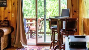A wooden interior with a sliding glass door leading to an outdoor deck. - Spacious 5 Bedroom Cabin Riverfront/Black Lake Access (Hammond)