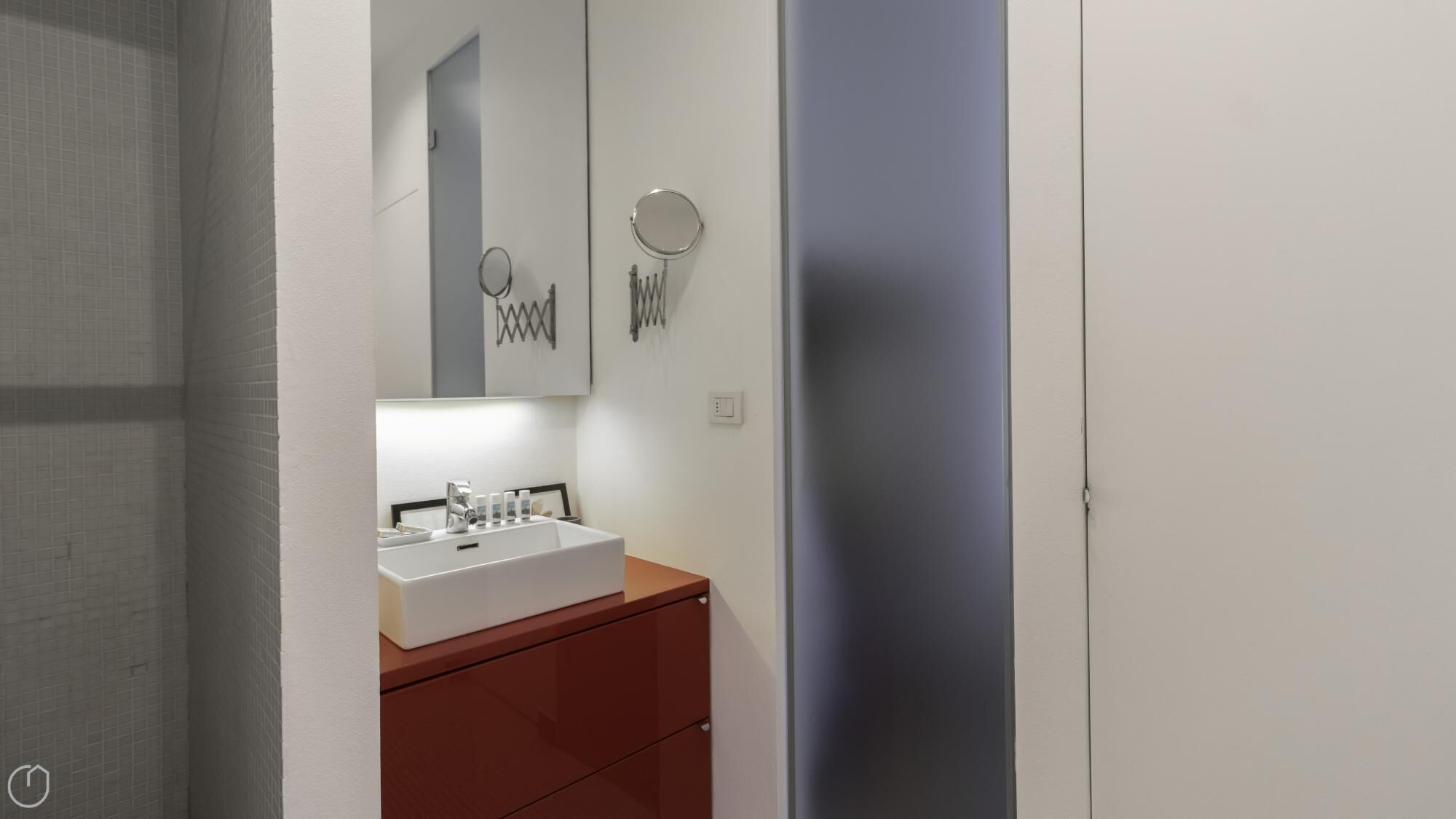 A bathroom with a white sink, a mirror, and a towel rack.