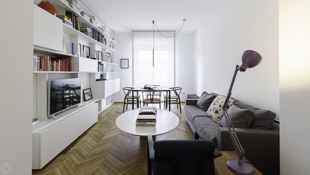 A modern living room with a white bookshelf, a flat-screen TV, a round coffee table, a grey sofa, and a floor lamp. - Italianway Comfort - Palestrina 31 (Milan)