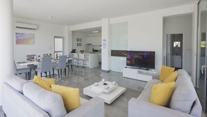 Uma sala de estar moderna com sofá, mesa de centro e televisão.