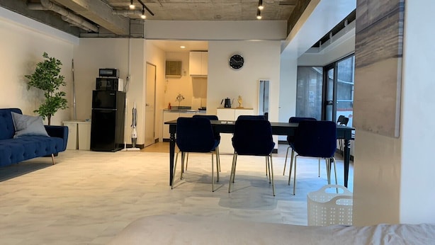 Un espacio habitable moderno con comedor, cocina y un amplio ventanal que proporciona luz natural.