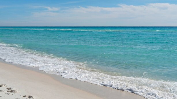 A beach with clear turquoise water and a sandy shore. - Private *Heated Pool | Free Golf Cart | New Home | Patio Area | 5 Outdoor Spaces | Game Table (Santa Rosa Beach)