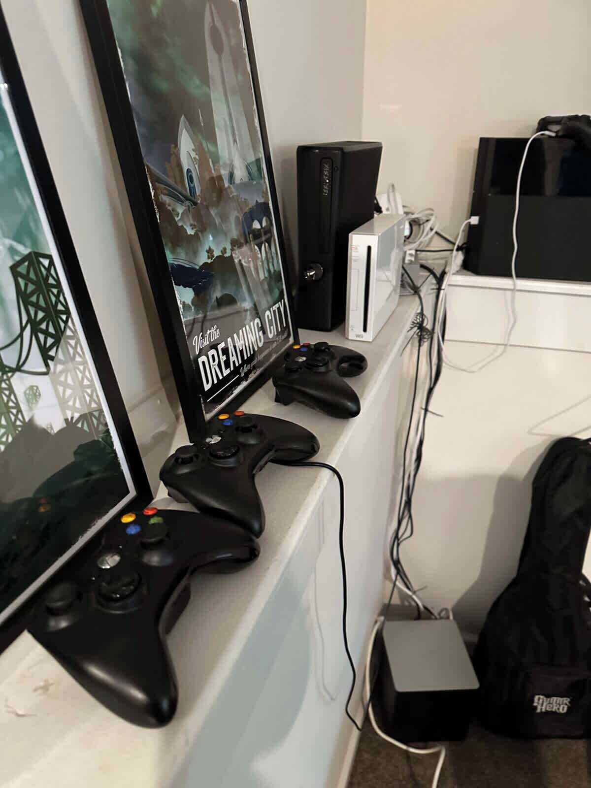 Un equipo de juego con un monitor, dos mandos, una consola PlayStation 4 y una guitarra.