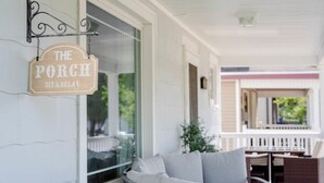 A porch with a sign reading "The Porch Sit & Relax".