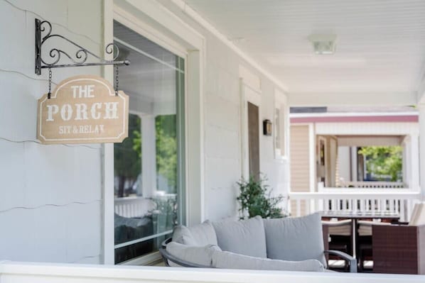 A porch with a sign reading "The Porch Sit & Relax".
