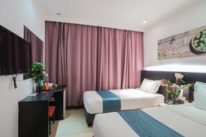 A hotel room with two beds, a desk, a TV, and a potted plant. - Floresta Hotel Chinatown (Kuala Lumpur)