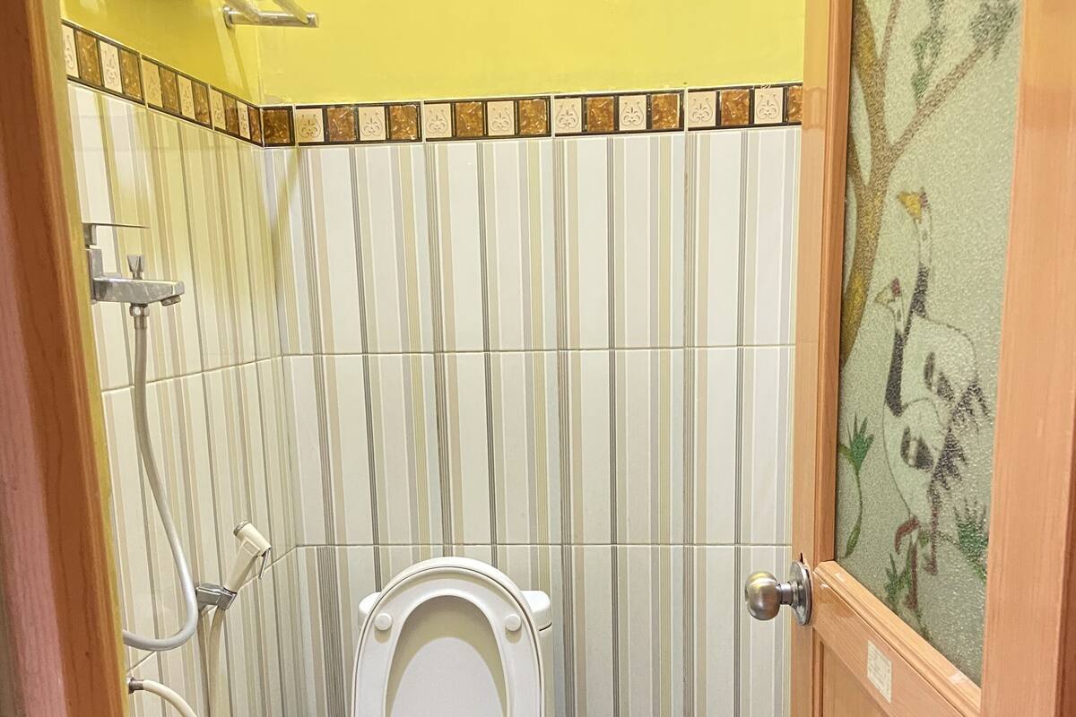 Une petite salle de bain avec des toilettes, une douche et un lavabo.