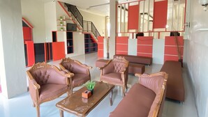 Un'ampia zona giorno con divano, tavolino e una scala che conduce a un piano superiore.