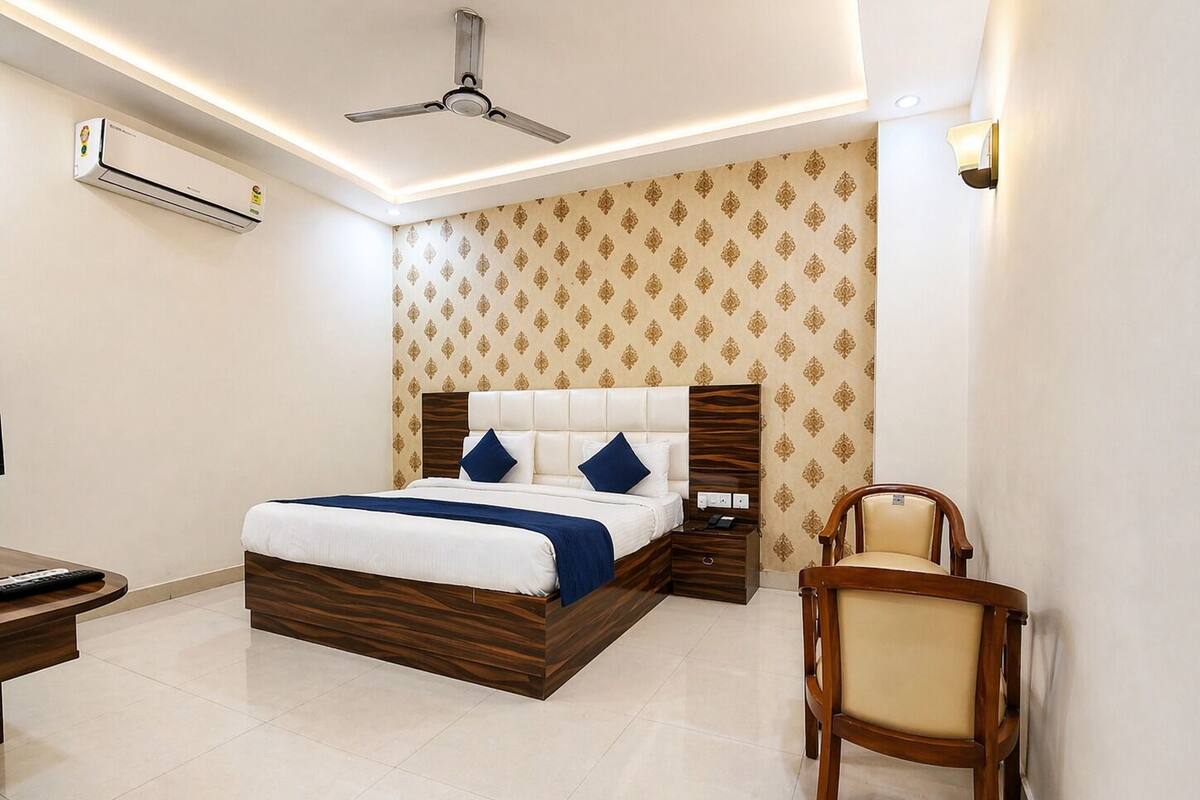Une chambre d’hôtel équipée d’un lit, d’une table de chevet, d’une chaise et d’un ventilateur de plafond.