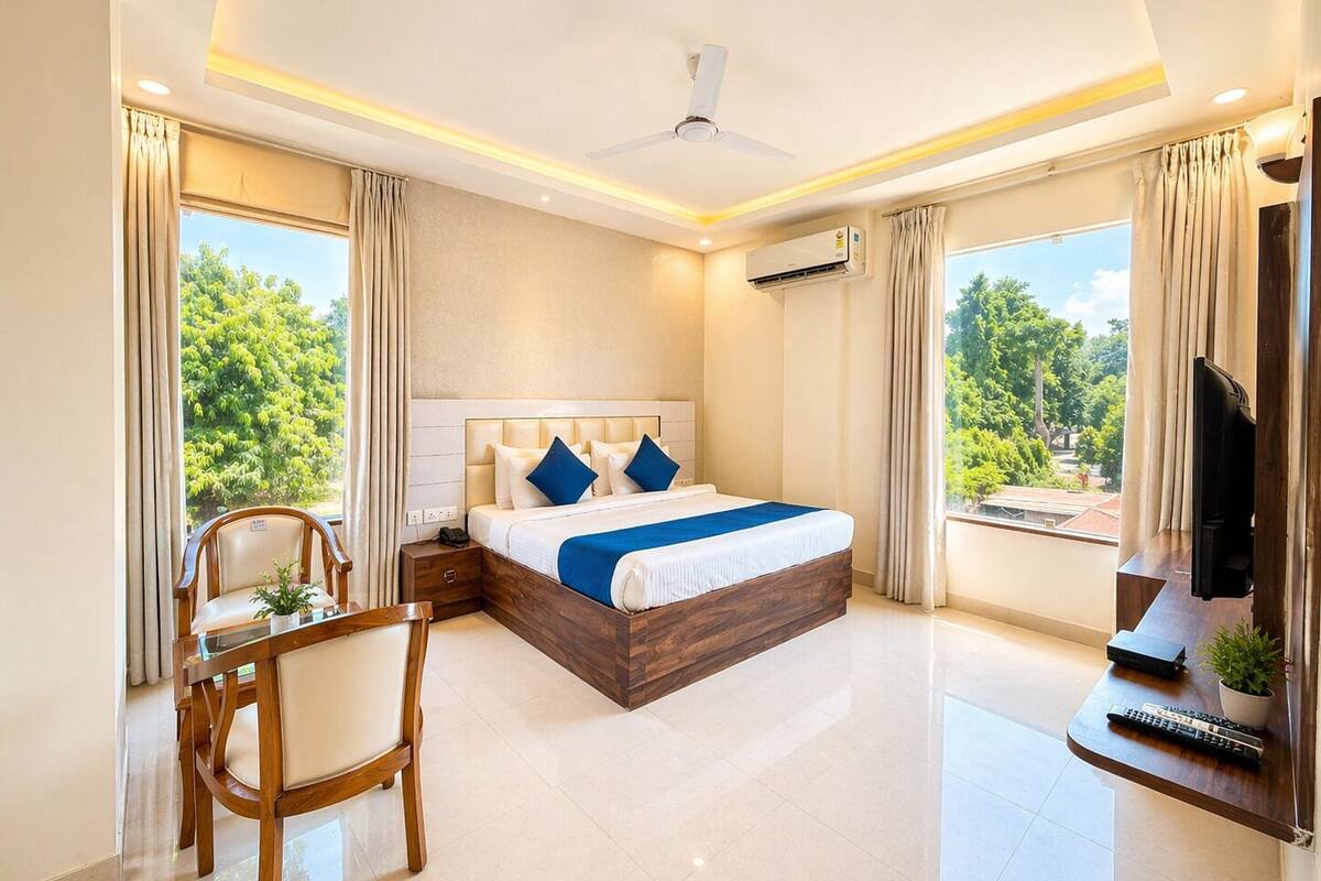 Une chambre d’hôtel moderne équipée d’un grand lit, d’un bureau, d’une chaise et d’un téléviseur.