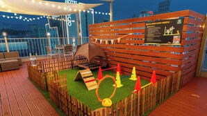 A rooftop deck with a play area for children, including a small tent, a jump rope, and a wooden fence. - WONJU Hotel Ippda (Wonju)