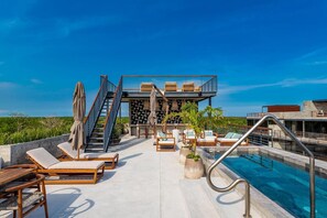 Piscine à débordement, piscine sur le toit, chaises longues