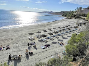 A beach with rows of sun loungers and umbrellas, a clear sky, and a calm sea. - Very cosy apartment with view in Las Ramblas Golf (VC)