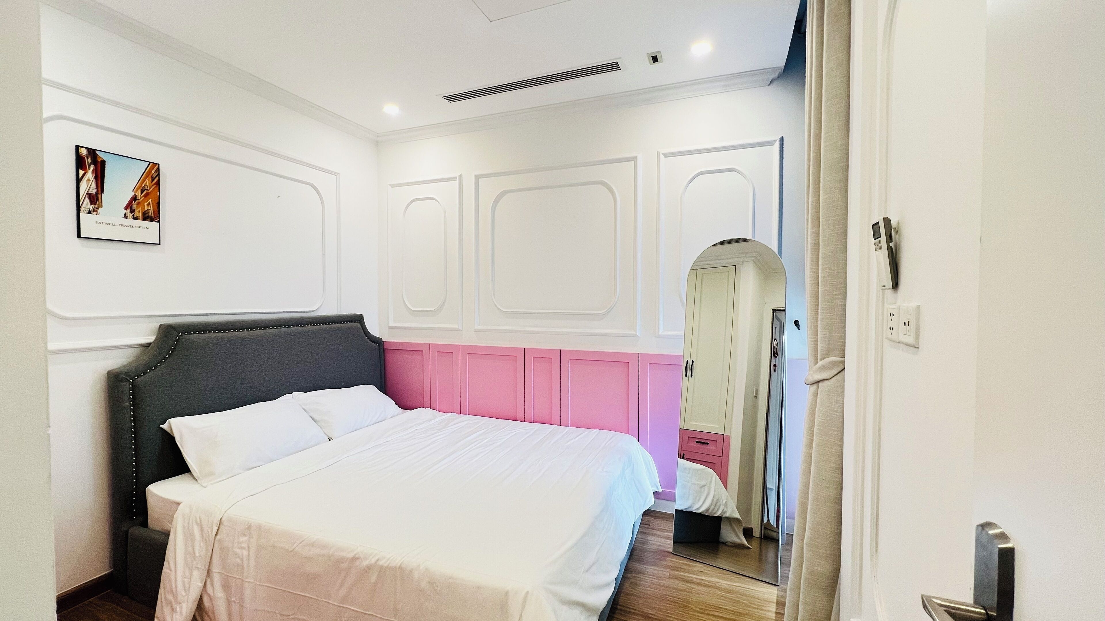 Ein Schlafzimmer mit einem Bett, einem Spiegel und einer Tür.