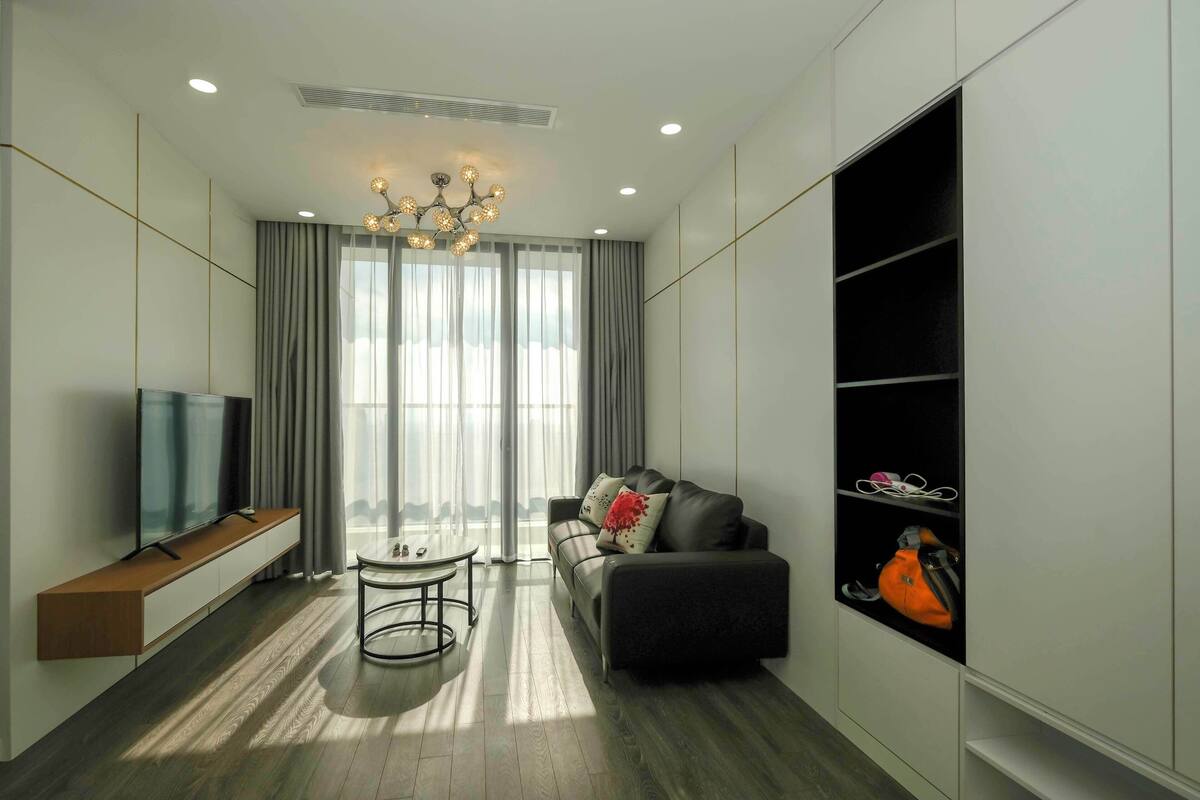 A modern living room with a sofa, TV, and a dining table.