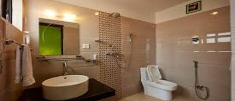 Un bagno moderno con un lavandino rotondo, un WC e una cabina doccia.