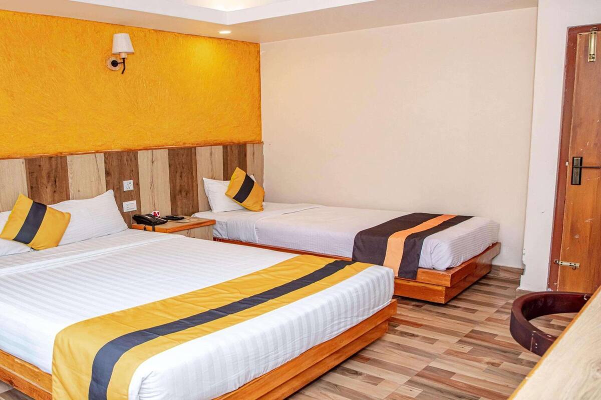 Ein Hotelzimmer mit zwei Betten, Holz-Kopfteilen und einem Holzschrank.