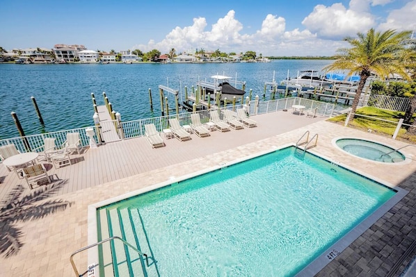 A swimming pool with a view of the water and buildings in the background.