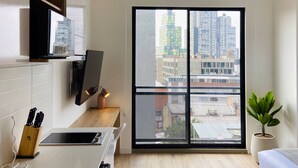 Una cocina moderna con horno integrado, un lavamanos y una encimera con un bloque para cuchillos.