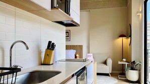 Una cocina moderna con un lavamanos de acero inoxidable, un bloque de cuchillos de madera y un lavavajillas integrado.