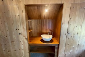 A wooden cabin-style bathroom with a built-in sink and a shelf. - Vacation home in Schoonloo with terrace (Schoonloo)