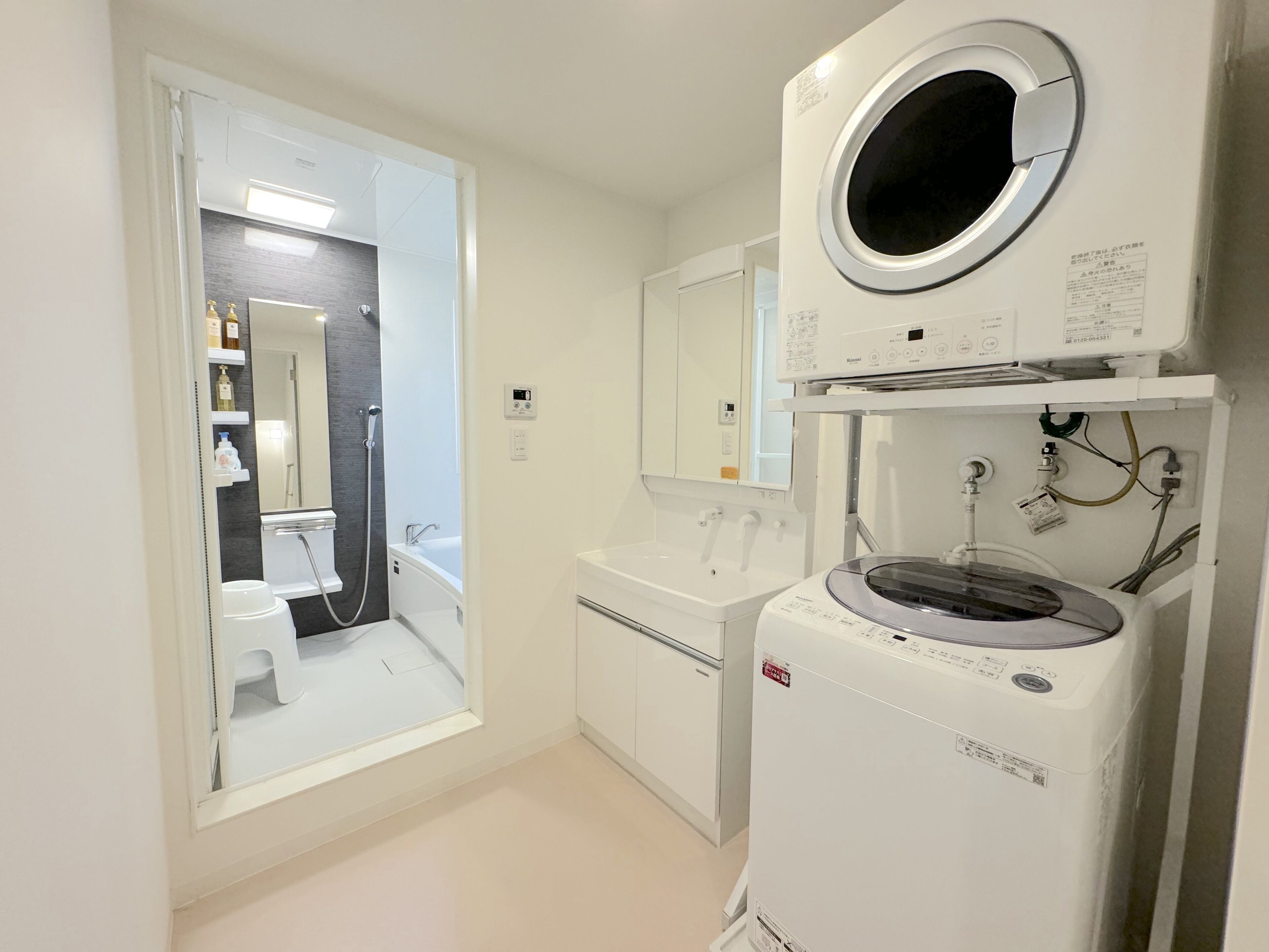 A modern bathroom with a toilet, sink, and a built-in washing machine.