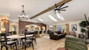A spacious living area with a dining table, chairs, a sofa, and a fireplace. - Harmony Ridge Ranch Nevada City (Nevada City)
