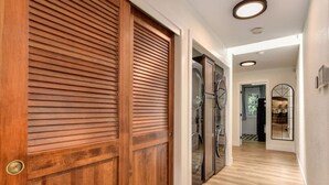 A hallway with wooden doors, a washing machine, and a glass door. - Harmony Ridge Ranch Nevada City (Nevada City)