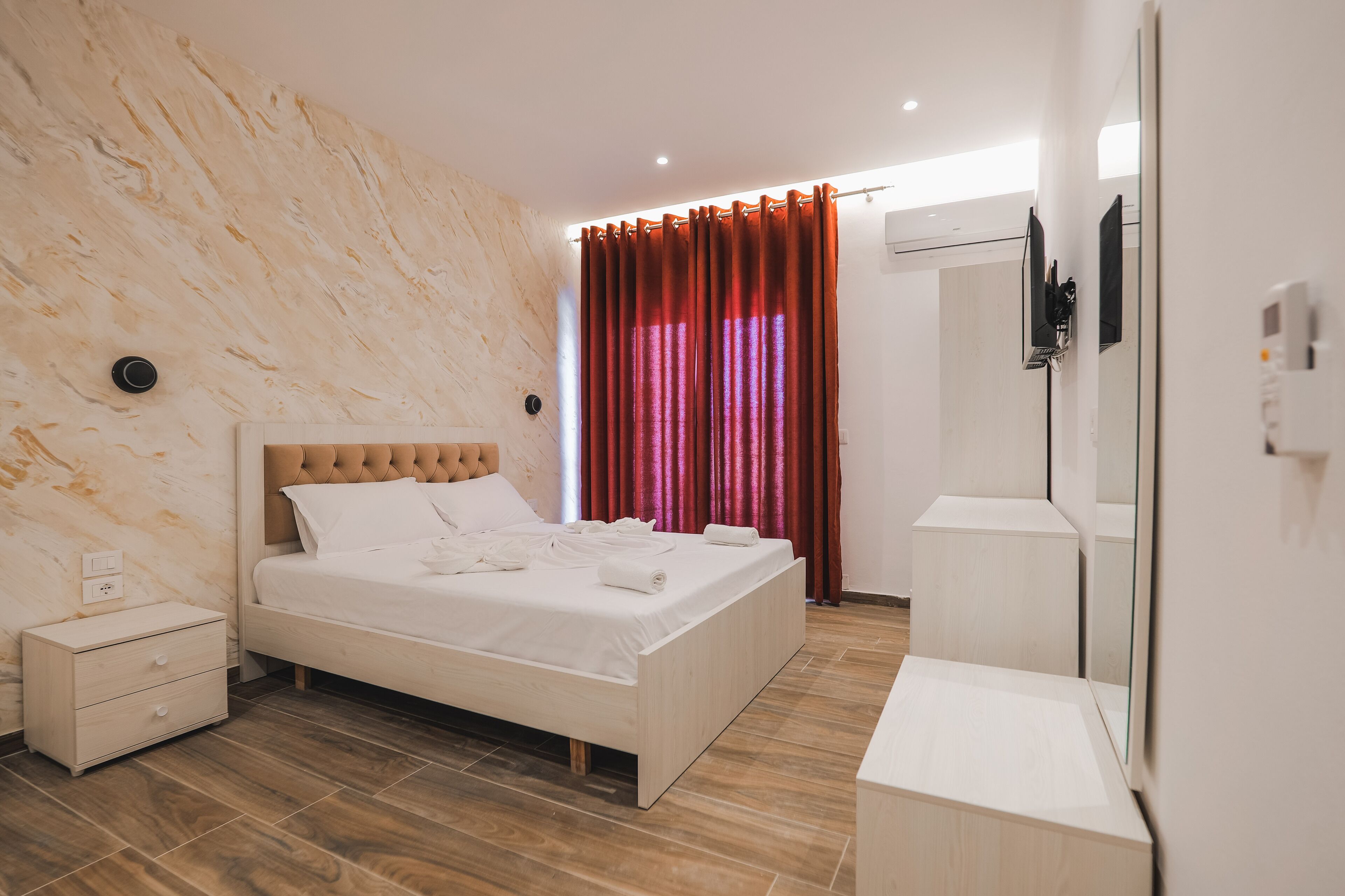 Ein modernes Schlafzimmer mit Bett, Nachttisch und Spiegel.