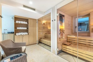 A modern spa room with wooden benches, a glass partition, and a wicker chair. - I Love Sylt Hotel Terminus ADULTS ONLY (Sylt)