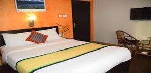 A hotel room with a bed, a chair, a desk, and a wall-mounted TV. - MeroStay 260 Hotel Rate (Kathmandu)