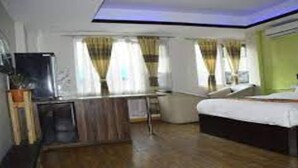 A hotel room with a bed, a desk, a chair, and a television. - MeroStay 260 Hotel Rate (Kathmandu)