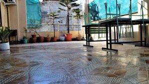 A spacious patio with tiled flooring, potted plants, and outdoor furniture. - MeroStay 260 Hotel Rate (Kathmandu)
