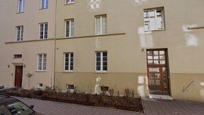 A multi-story residential building with a beige facade, multiple windows, and a door labeled "ORION". - City Lights Skawińska (Kraków)