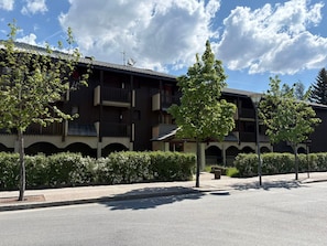 A multi-story building with balconies, a sign reading 'GRAND SURF,' and a clear sky.