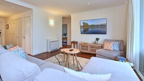 Ein Wohnzimmer mit einer Couch, einem Couchtisch und einem Gemälde an der Wand.
