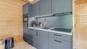 A modern kitchen with grey cabinets, a stainless steel sink, and a built-in oven.