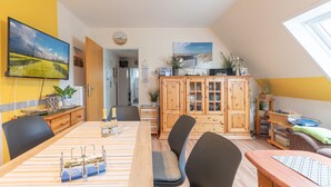 A dining area with a wooden table, chairs, and a view of the hallway. - Gode Sünn vacation apartment in Tating for up to 4 people (Tating)