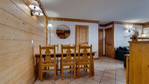 Un intérieur en bois comprenant une table et des chaises, un miroir et une lampe.