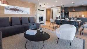Uma sala de estar moderna com sofá, mesa de centro e área de jantar com cadeiras e mesa.