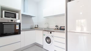 A modern kitchen with built-in appliances including a microwave, oven, washing machine, and refrigerator.